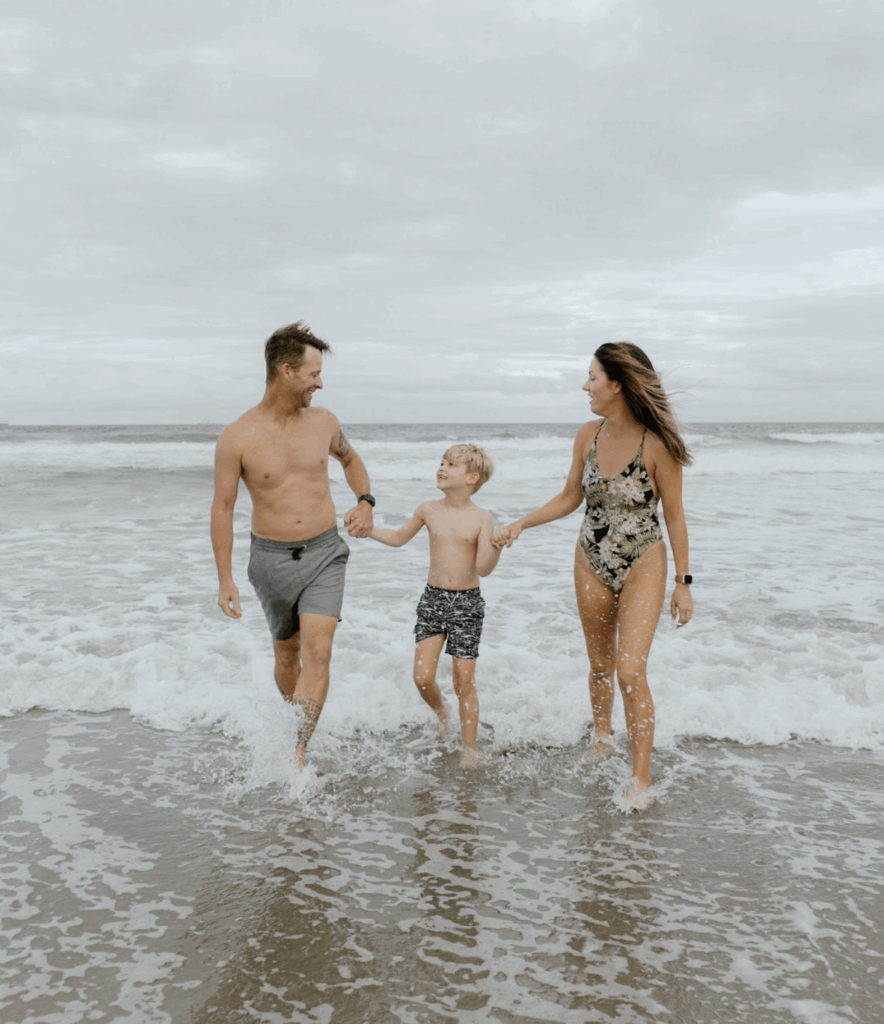 Family holding hands in the waves of Cocoa Beach, Florida